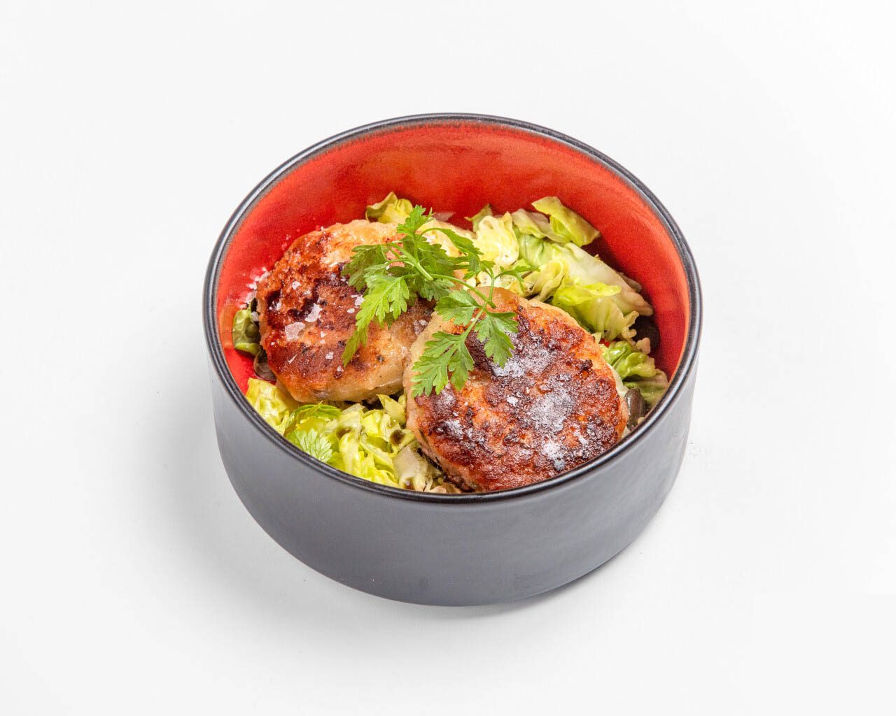 Kaspressknödel mit Romanasalat, Kernöl, gerösteten Kürbiskernen und Schnittlauch