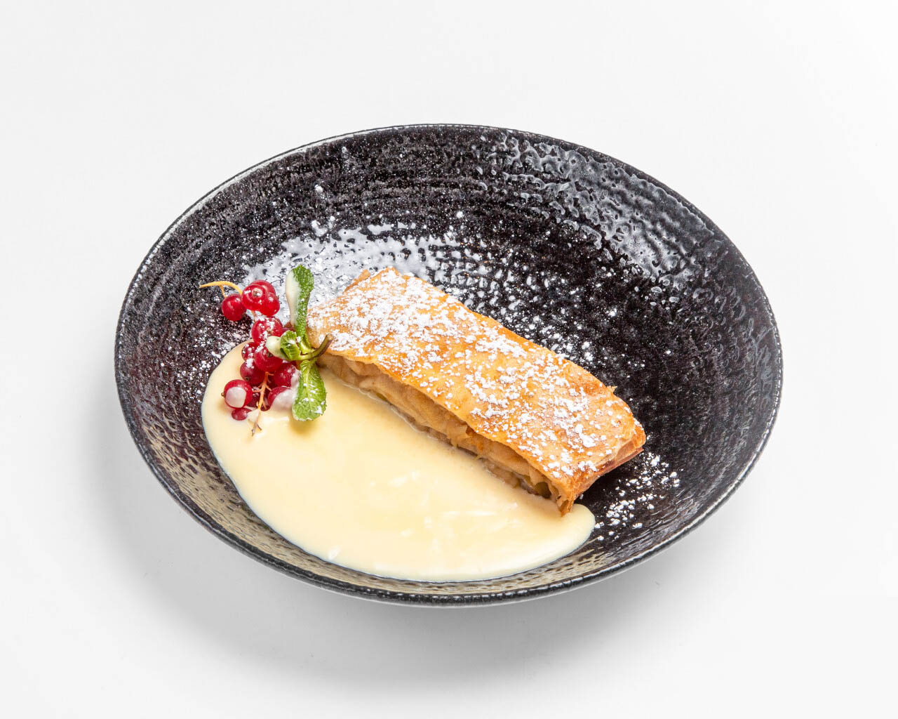 2025_0026_eli_schwabing_apfelstrudel_550x440 Apfelstrudel mit Vanillesoße , serviert auf dunklem Teller