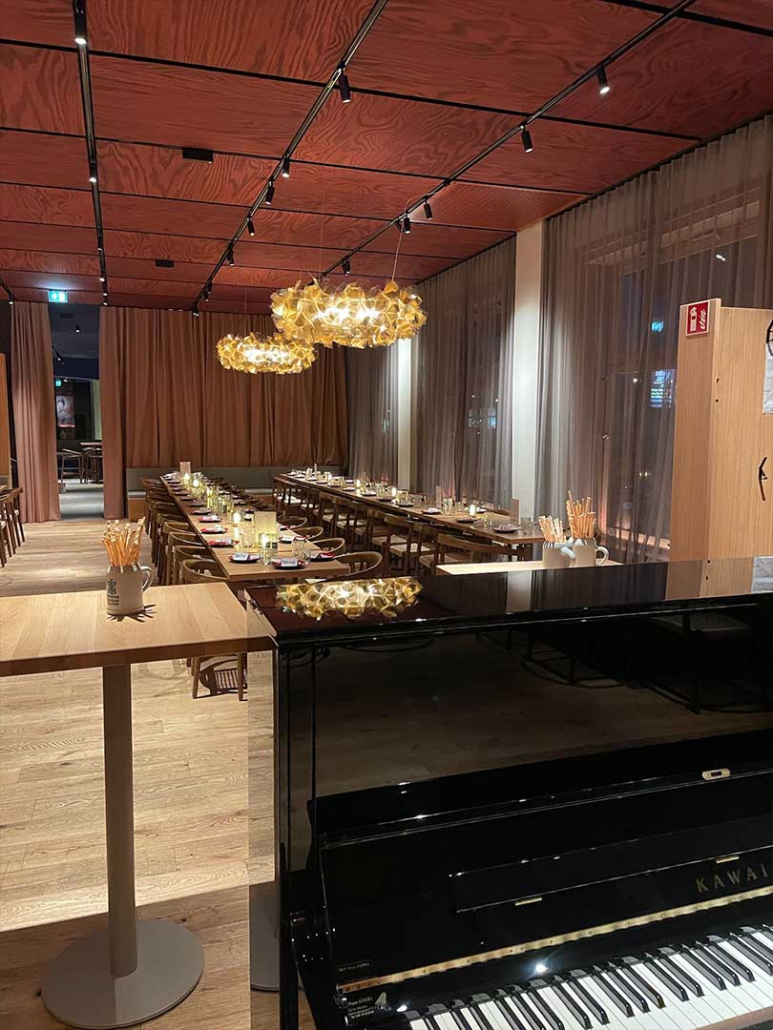 Blick in den Veranstaltungsraum des Restaurant ELI Schwabing mit zusammengestellten Tischen und gedeckter Tafel.