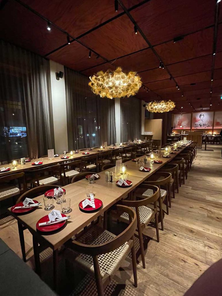 Großer Veranstaltungsraum im Restaurant ELI Schwabing mit langen Tischreihen und warmem Lichtkonzept.