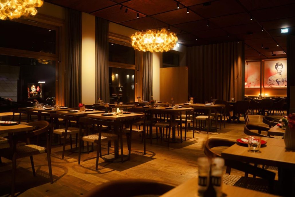 Restaurantbereich mit Sitzplätzen und Blick auf Sisi Wandgemälde.